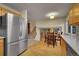 Open-concept kitchen flows into a dining area, complete with wood floors and a stainless steel refrigerator at 12028 W Aqueduct Dr, Littleton, CO 80127