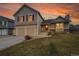 Charming two-story home featuring a two-car garage and a well-manicured front lawn under a beautiful sunset sky at 12028 W Aqueduct Dr, Littleton, CO 80127