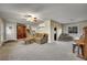 Spacious living room featuring a staircase, sofa, piano and abundant natural light, creating an inviting atmosphere at 12028 W Aqueduct Dr, Littleton, CO 80127