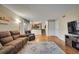 Spacious living room featuring hardwood floors, comfortable seating, and access to the dining area at 12028 W Aqueduct Dr, Littleton, CO 80127