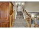 Carpeted staircase leading to the upper level of the home with wooden banisters and a security gate at 12028 W Aqueduct Dr, Littleton, CO 80127