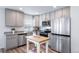 A modern kitchen featuring stainless steel appliances, gray cabinets and a butcher block style island at 13563 E 103Rd Pl, Commerce City, CO 80022