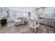 Bright and open-concept living room and kitchen featuring wood floors, a modern sofa, and large windows at 13563 E 103Rd Pl, Commerce City, CO 80022