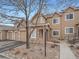 Tan two-story townhome with stone accents, attached garage, and landscaped walkway at 2833 W 119Th Ave # 15-102, Denver, CO 80234