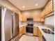 Well-lit kitchen with stainless steel appliances, light wood cabinets, and a tile floor at 2833 W 119Th Ave # 15-102, Denver, CO 80234