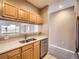Kitchen sink features light wood cabinets, stainless steel dishwasher, and bar seating to living room at 2833 W 119Th Ave # 15-102, Denver, CO 80234