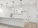 Basement bar area with modern pendant lighting, white cabinets, and stainless steel appliances at 4066 N Irvington St, Aurora, CO 80019