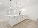 Basement bar with a countertop featuring white cabinets, pendant lights, and plank floors at 4066 N Irvington St, Aurora, CO 80019