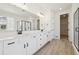 Bright bathroom featuring double vanity with black hardware, large mirror, and a glass enclosed shower at 4066 N Irvington St, Aurora, CO 80019
