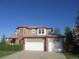 Two-story home with a 2-car garage, brick accents, and a well-manicured lawn on a sunny day at 518 Zircon Way, Superior, CO 80027