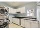 This laundry room includes a washer/dryer, sink, and cabinets at 518 Zircon Way, Superior, CO 80027