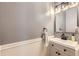 This half-bathroom features wainscotting and a modern vanity with a black faucet and hardware at 9264 Fox Fire Ln, Highlands Ranch, CO 80129