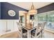 Elegant dining room featuring a modern chandelier, blue accent wall, and ample natural light at 9264 Fox Fire Ln, Highlands Ranch, CO 80129