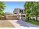 A two-story home with a front porch and a wide driveway leading to a two-car garage at 9264 Fox Fire Ln, Highlands Ranch, CO 80129