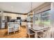 Eat-in kitchen features white cabinetry, stainless appliances, granite countertops, and hardwood floors at 9264 Fox Fire Ln, Highlands Ranch, CO 80129