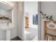 Modern bathroom with a sleek pedestal sink and a view into a bright, minimalist room at 3011 W 53Rd Ave, Denver, CO 80221