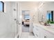 Bathroom leading to bedroom; walk-in shower with double sink and stone countertop at 3011 W 53Rd Ave, Denver, CO 80221
