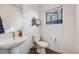 Chic powder room with modern pedestal sink, tiled floor, and natural light from the window at 3011 W 53Rd Ave, Denver, CO 80221