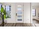 Bright entryway featuring a modern door with glass inserts, stylish flooring, and a lush indoor plant at 3011 W 53Rd Ave, Denver, CO 80221