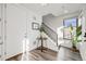Inviting foyer with modern staircase, stylish table decor, and ample natural light streaming through the window at 3011 W 53Rd Ave, Denver, CO 80221