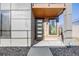 Modern townhome entrance features a stylish door with glass panels, accented by contemporary lighting and design at 3011 W 53Rd Ave, Denver, CO 80221