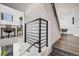Modern staircase with metal railing, leading to a bright living area with stylish furniture and decor at 3011 W 53Rd Ave, Denver, CO 80221