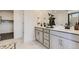 Bright bathroom with double sinks, modern cabinetry, and a walk-in closet nearby at 16947 W 92Nd Dr, Arvada, CO 80007