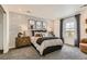 Cozy bedroom with patterned accent wall, plush carpet, and decoratively styled with matching bedside tables at 16947 W 92Nd Dr, Arvada, CO 80007