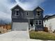 Two-story home featuring gray siding, white trim, and an attached two-car garage at 16947 W 92Nd Dr, Arvada, CO 80007