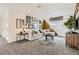 Bright living room area featuring a modern-styled sectional sofa, decorative artworks, and plush carpeting at 16947 W 92Nd Dr, Arvada, CO 80007
