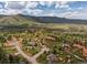 Aerial view of several homes nestled within a community surrounded by trees, rocks, and mountains at 6619 Apache Pl, Larkspur, CO 80118