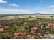 Aerial view of homes nestled within a picturesque landscape, with rock formations, trees, and open fields at 6619 Apache Pl, Larkspur, CO 80118
