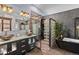 Luxurious bathroom featuring a standalone tub, glass shower, double vanity, and modern fixtures at 6619 Apache Pl, Larkspur, CO 80118