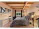 Cozy bedroom featuring wood floors, exposed beam ceiling, and monochrome decor at 6619 Apache Pl, Larkspur, CO 80118