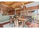 Dining area featuring unique rock wall, access to a balcony, and wood floors at 6619 Apache Pl, Larkspur, CO 80118