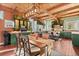 Well-lit dining area with wood floors, adjacent to a kitchen with glass faced cabinets at 6619 Apache Pl, Larkspur, CO 80118