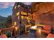 Exterior view of a unique home featuring a stone fire pit on a wooden deck and natural rock at 6619 Apache Pl, Larkspur, CO 80118