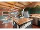 Rustic kitchen featuring wood floors and island, green cabinets, stainless appliances, and a breakfast nook with mountain views at 6619 Apache Pl, Larkspur, CO 80118