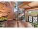Unique living area with hardwood floors, wood beams, and access to balconies, featuring natural rock at 6619 Apache Pl, Larkspur, CO 80118