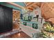 Open living room with exposed wood beam ceiling, unique rock detail and wood slat decoration at 6619 Apache Pl, Larkspur, CO 80118