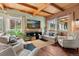 Cozy living room with beamed ceilings, neutral furniture, and views of the rock formations outside at 6619 Apache Pl, Larkspur, CO 80118
