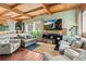 Inviting living room featuring wood-beam ceiling, hardwood floors, and cozy seating arrangement at 6619 Apache Pl, Larkspur, CO 80118