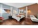 Bright main bedroom with wood floors, accent wall, and views of the natural rock formations at 6619 Apache Pl, Larkspur, CO 80118