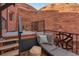 Relaxing patio with a lounge chair, built-in hot tub, privacy fence, and views of the natural rock formations at 6619 Apache Pl, Larkspur, CO 80118