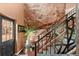Unique staircase with a natural rock wall backdrop, modern metal railing, and a view of the front door at 6619 Apache Pl, Larkspur, CO 80118