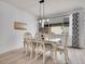 Well-lit dining area with an elegant wooden table, stylish chairs, and a modern chandelier at 22898 E Ottawa Pl, Aurora, CO 80016
