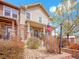 Charming townhome featuring a stone facade, covered porch, and American flag at 22898 E Ottawa Pl, Aurora, CO 80016