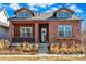 Attractive brick home with dormer windows and a welcoming front porch, surrounded by well-maintained landscaping at 5876 Alton St, Denver, CO 80238