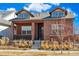 Inviting brick home featuring dormer windows and a cozy front porch, complemented by tidy landscaping at 5876 Alton St, Denver, CO 80238