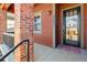 Close up of front porch with brick support beam and a decorative front door at 5876 Alton St, Denver, CO 80238
